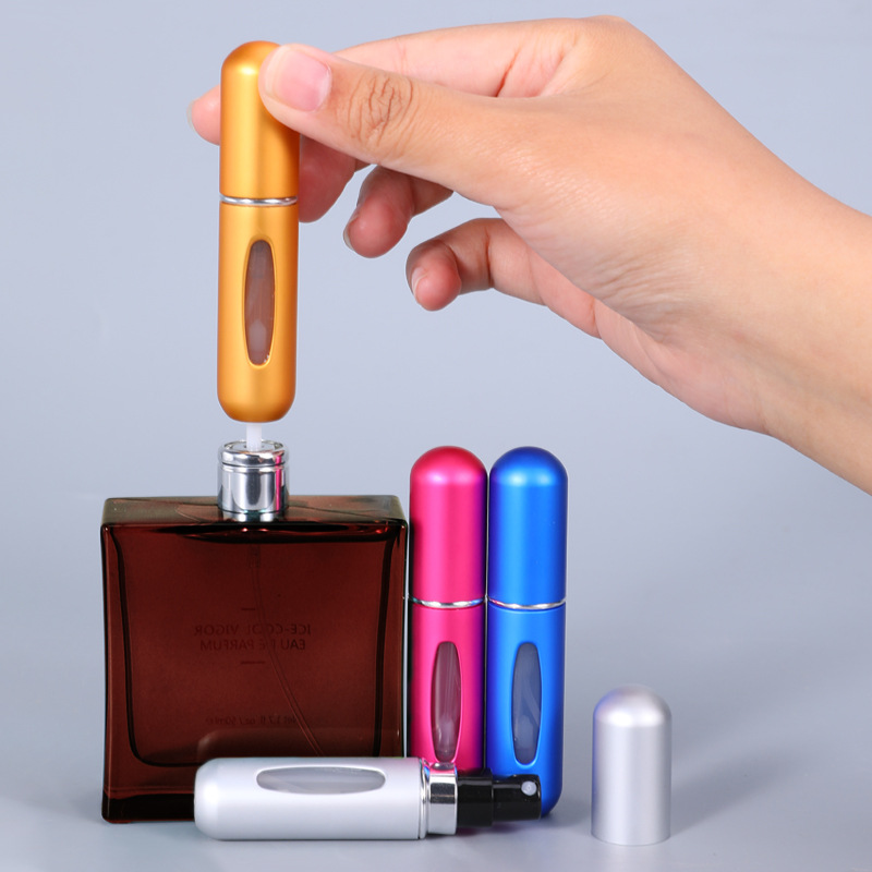 A person inserting a small glass refill vial into a reusable, stylish outer spray bottle