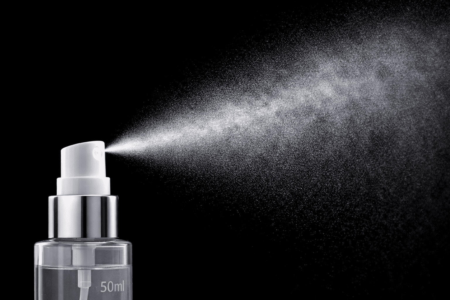 Close-up of an ultra-fine, cloud-like mist spraying from a nozzle against a dark background