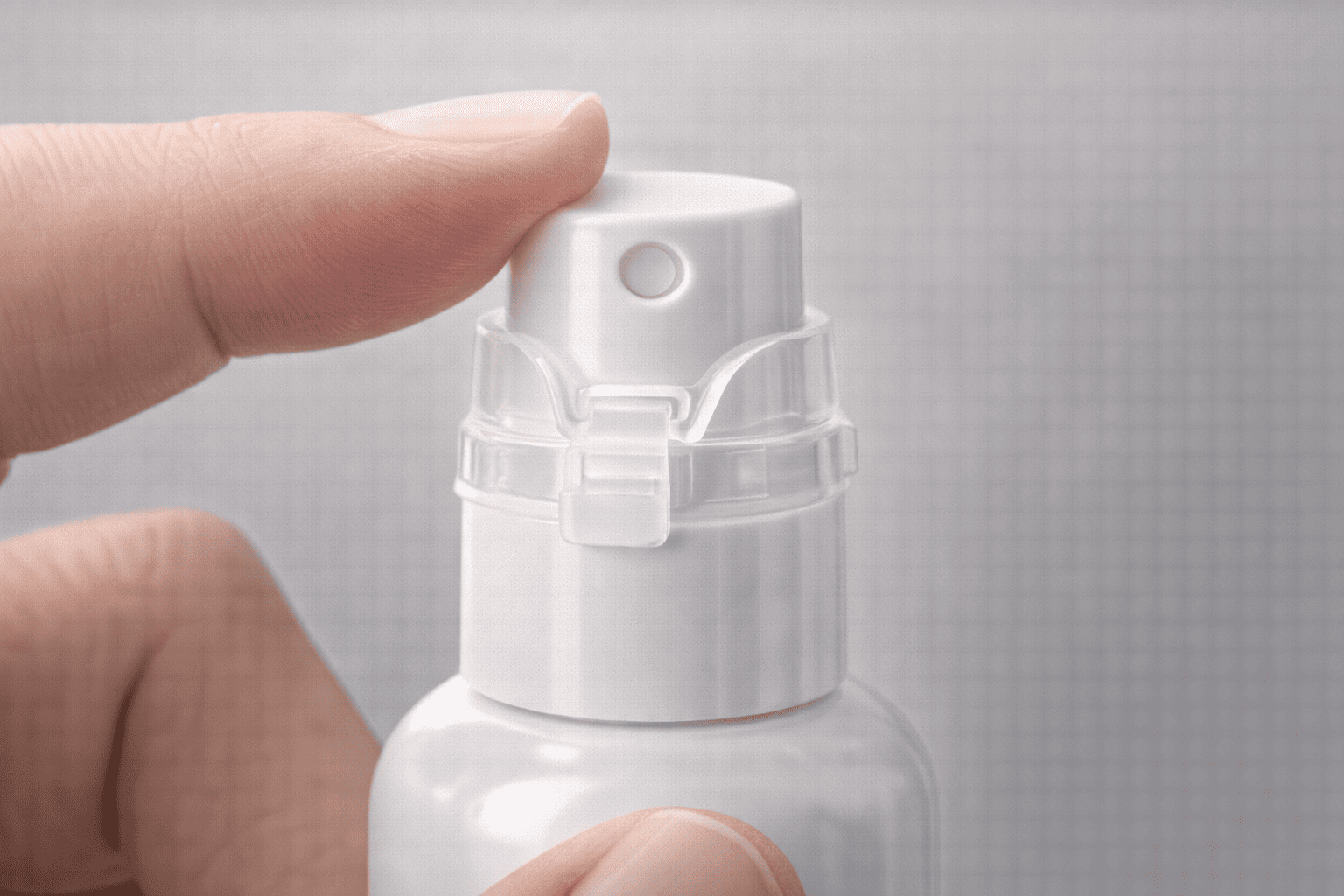 A close-up view of a spray pump secured with a small plastic clip lock that prevents the pump from being pressed