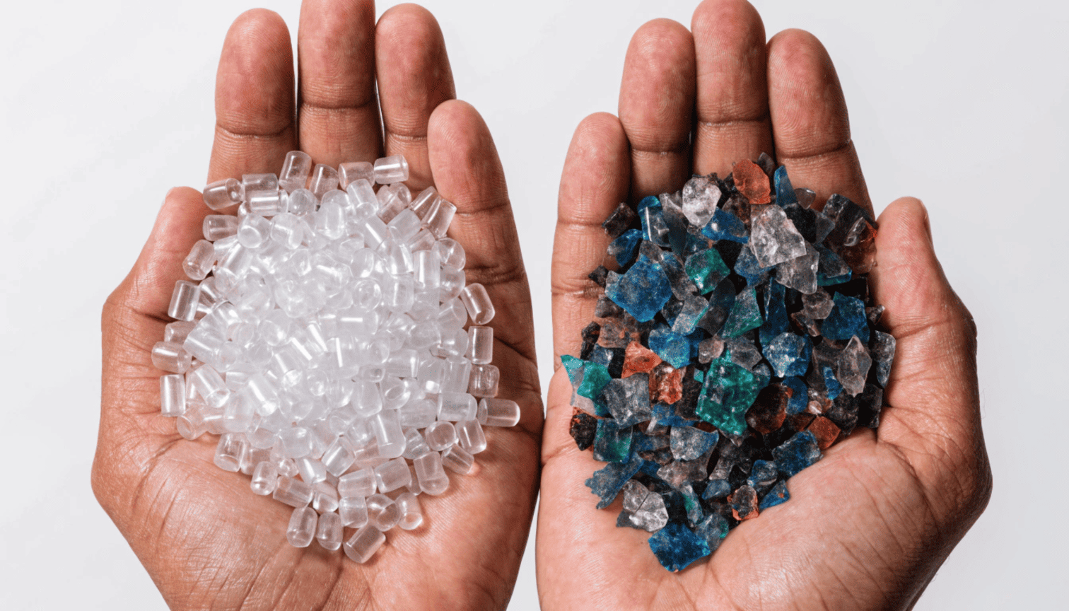 Clear virgin plastic pellets in one hand and mixed recycled plastic flakes in the other hand showing material quality difference