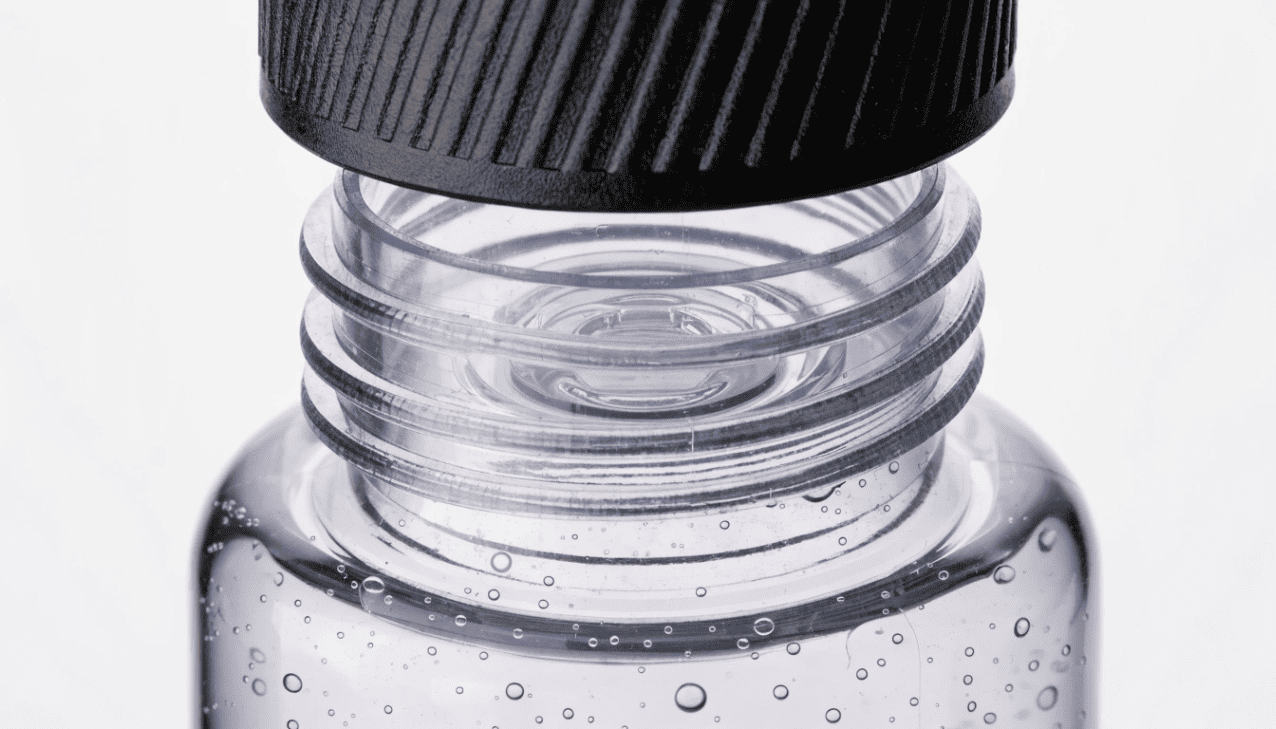 A detailed close up of a sunscreen bottle neck showing tight threads and a sealing gasket to prevent leakage